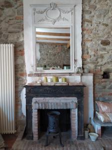 Una chimenea en una habitación con un espejo encima. en The Bergamot, en Tursi
