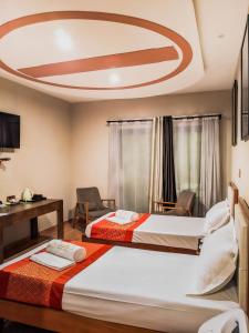 2 łóżka w pokoju hotelowym z sufitem w obiekcie Valiha Hotel Antananarivo w Antananarywie