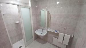 a bathroom with a sink and a shower and a mirror at Motel Montecarlo in Teo