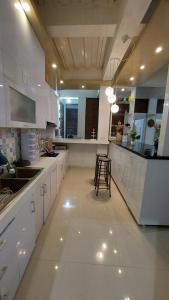 uma cozinha com armários brancos e uma mesa em Teras Luhur Villa & Cafe dengan Pemandangan Gunung dan Pesawahan 