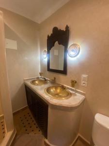baño con 2 lavabos, espejo y aseo en Riad Al Karama, en Marrakech