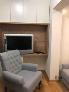 een woonkamer met een stoel en een tv bij Vila Pahulja in Kopaonik