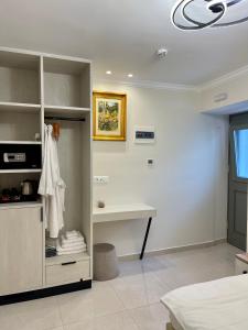 a white room with a desk and a bed at Aesthesis Arxontiko Luxury Rooms in Myrina