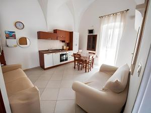 een woonkamer met een bank en een tafel bij Monolocale finemente ristrutturato in Ostuni