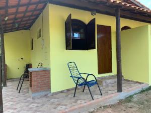 a yellow house with two chairs in front of it at Rancho Cavalo Mania in São Roque