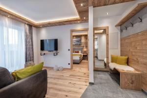 salon z kanapą i telewizorem w obiekcie Apartment NH96 inklusive kostenfreiem Eintritt in die Alpentherme w mieście Bad Hofgastein