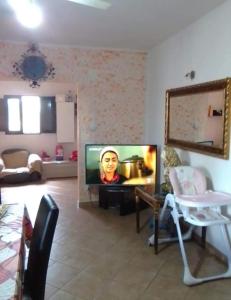 a living room with a television with a woman on it at Independent apartment from Vincenza in Lentini