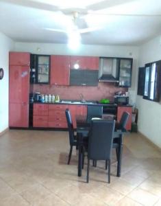 a kitchen with red cabinets and a table and chairs at Independent apartment from Vincenza in Lentini