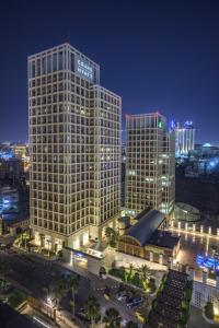 - une vue sur un grand bâtiment de la ville la nuit dans l'établissement Grand Hyatt Amman Residences, à Amman