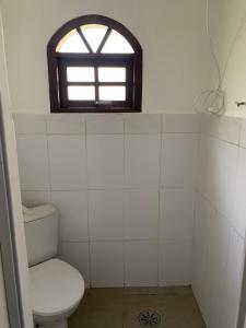 a bathroom with a toilet and a window at Rancho Cavalo Mania in São Roque
