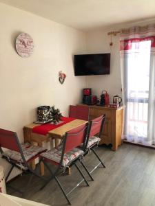 a dining room with a table and chairs and a television at Le Bouquetin - Immeuble Le Pluton in Les Deux Alpes