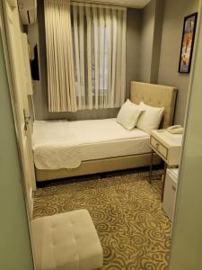 a small room with a bed and a window at Mr BEYAZ HOTEL in Istanbul