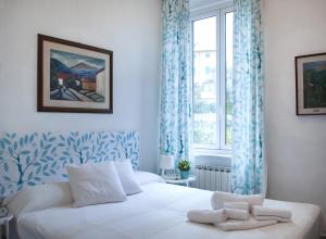 una camera da letto con un letto bianco con tende blu e una finestra di Il tempo è l'essenza della vita a Santa Margherita Ligure