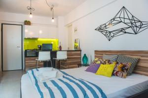 a bedroom with a large bed with colorful pillows at Mazi Rooms Venizelou in Thessaloniki