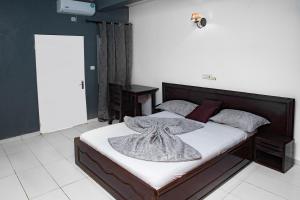 - une chambre avec un lit et une couverture dans l'établissement krEMLin, à Douala