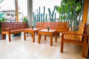3 bancos de madera sentados en una habitación con ventana en krEMLin en Duala