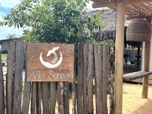una cerca de madera con un cartel que dice viet saga en Vila Sereia Caraiva, en Caraíva