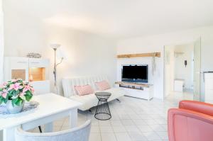 ein Wohnzimmer mit einem Sofa und einem TV in der Unterkunft Ferienwohnung Lux in Überlingen