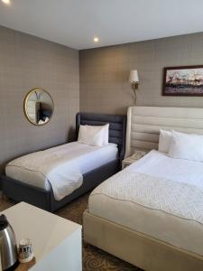 a hotel room with two beds and a mirror at Mr Beyaz Hotel Sisli Istanbul in Istanbul +26 photos