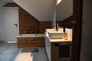 een badkamer met een wastafel en een bad bij Willa Muszyna in Muszyna