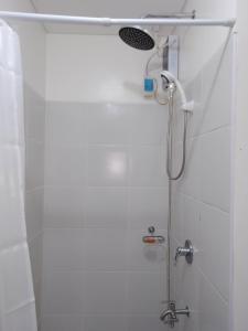 a shower with a shower head in a bathroom at 2BR Pioneer Woodlands SM LIGHT by AwayHome Rentals in Manila