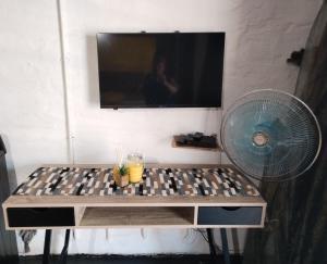 a table with a fan and a tv on a wall at Maboneng Precinct Johannesburg - Craftsmenship Apartments in Johannesburg