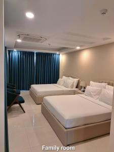 a bedroom with two beds and a family room at Ruby Hotel in Ho Chi Minh City