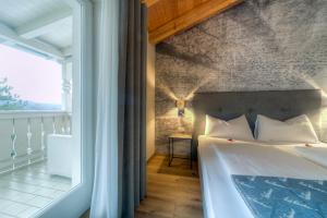 a bedroom with a bed and a large window at Eden Apartments in Siusi