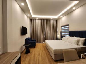 a bedroom with a large bed and a blue chair at Ruby Hotel in Ho Chi Minh City