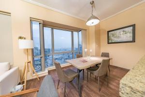 a dining room with a table and chairs and a large window at Stunning 1 bedroom w pool in Downtown in Dubai