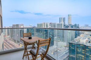 a table and chairs on a balcony with a view of a city at Stunning 1 bedroom w pool in Downtown in Dubai