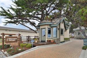 a small house with a bench in front of a building at Moonstone Cottages in Cambria