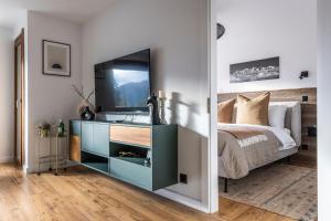 1 dormitorio con 1 cama y vestidor con TV en La Ruinette - Modern 1 Bed, 3 Mins From Cable Car, en Verbier