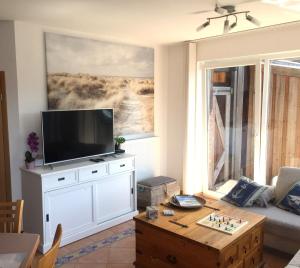 sala de estar con TV y mesa de centro en Ferienwohnung Seegang 25493, en Weener