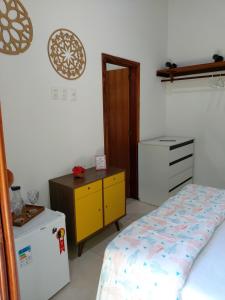 1 dormitorio con 1 cama, vestidor y nevera en Cafofo de Dri en Ilha de Boipeba