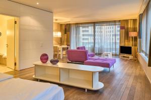 pokój hotelowy z łóżkiem i fioletowymi meblami w obiekcie Limmathof Baden - Boutique Haus & Spa w mieście Ennetbaden