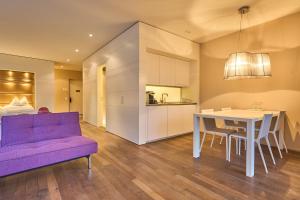 een woonkamer met een paarse bank en een tafel bij Limmathof Baden - Boutique Haus & Spa in Ennetbaden