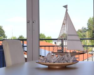 a model sailboat on a plate on a table at Ferienwohnung Landgang 25494 in Weener