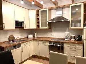a kitchen with white cabinets and a stove top oven at Ferienwohnung Landgang 25494 in Weener