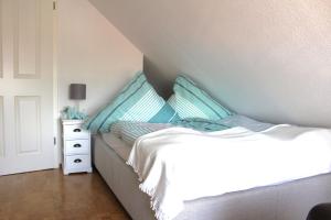una camera da letto con un letto con cuscini blu di Ferienwohnung Landgang 25494 a Weener