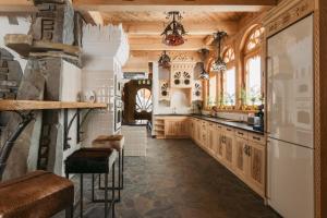 a kitchen with wooden cabinets and a large window at Art House Residence in Białka Tatrzanska