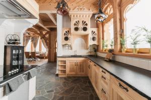 a kitchen with wooden cabinets and a black counter top at Art House Residence - Grand Luxury Villa - Mountain & Ski in Białka Tatrzańska