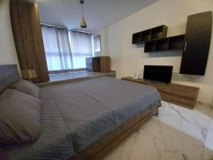 a bedroom with a large bed and a television at Brand new 1 bedroom studio flat in Gudja