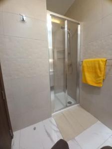 y baño con ducha y toalla amarilla. en Brand new 1 bedroom studio flat en Gudja