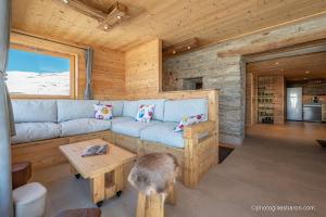 a living room with a blue couch in a log cabin at Le Refuge Ibex - Chalet d'Alpage au coeur de la nature - 8 personnes in Orcières