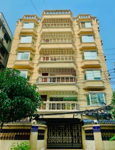 een hoog geel gebouw met balkons erop bij Hotel Heaven Inn in Dhaka