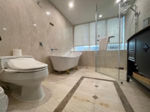 een badkamer met een bad, een toilet en een bad bij Wowhappy Daan in Taipei
