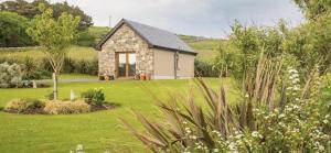 una pequeña casa de piedra en medio de un patio en ocean view cleggan en Cleggan