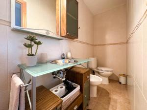 La salle de bains est pourvue d'un lavabo et de toilettes. dans l'établissement Orilla de Mar: Vistas de ensueño en Cala Almadraba, à El Campello