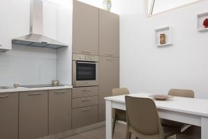 cocina con mesa y encimera blanca en La Forgia - Guest House, en Santo Stefano di Camastra